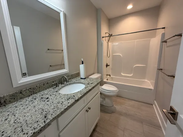 a bathroom with a granite countertop sink toilet and shower