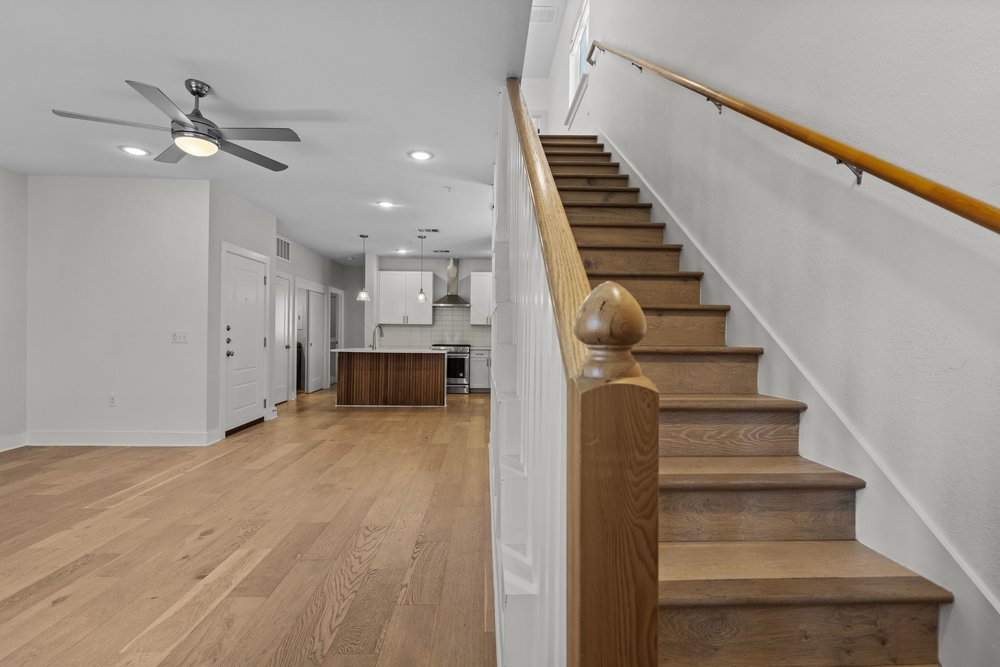2827 Manor Road, Unit 2201 Austin, TX 78722 - Photo 22 of 40 Wood-finish staircase with white risers and a light wood handrail