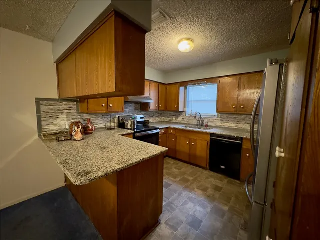 a kitchen with a sink dishwasher stove and refrigerator