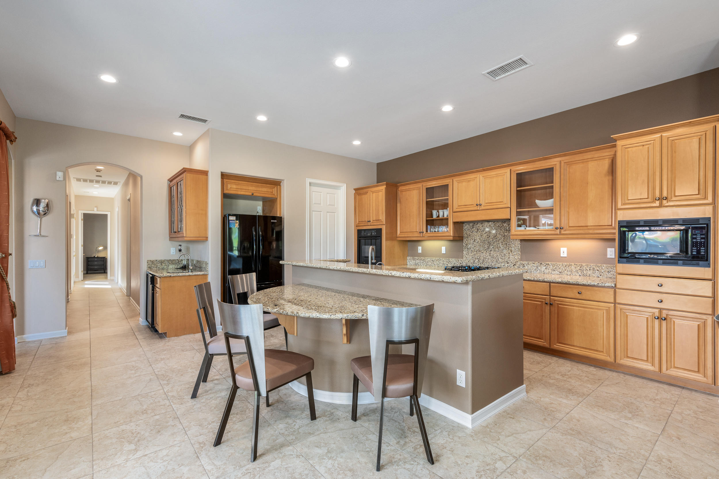 360 Loch Lomond Road Rancho Mirage, CA 92270 - Photo 16 of 76 a kitchen with stainless steel appliances granite countertop dining table chairs refrigerator and sink
