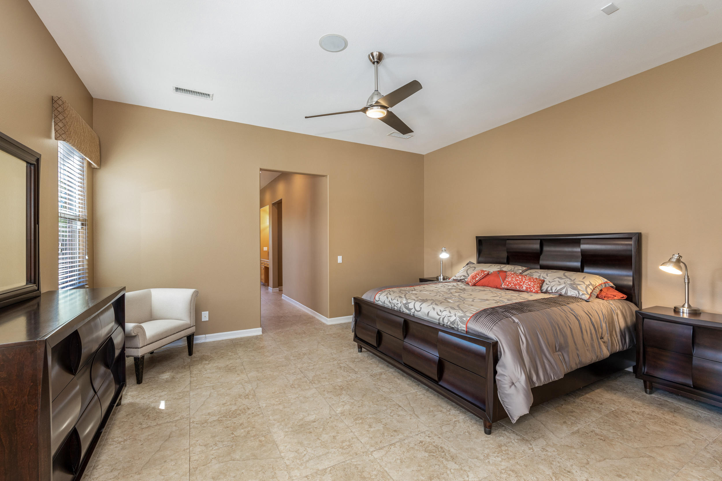 360 Loch Lomond Road Rancho Mirage, CA 92270 - Photo 23 of 76 a bedroom with a bed and a chandelier