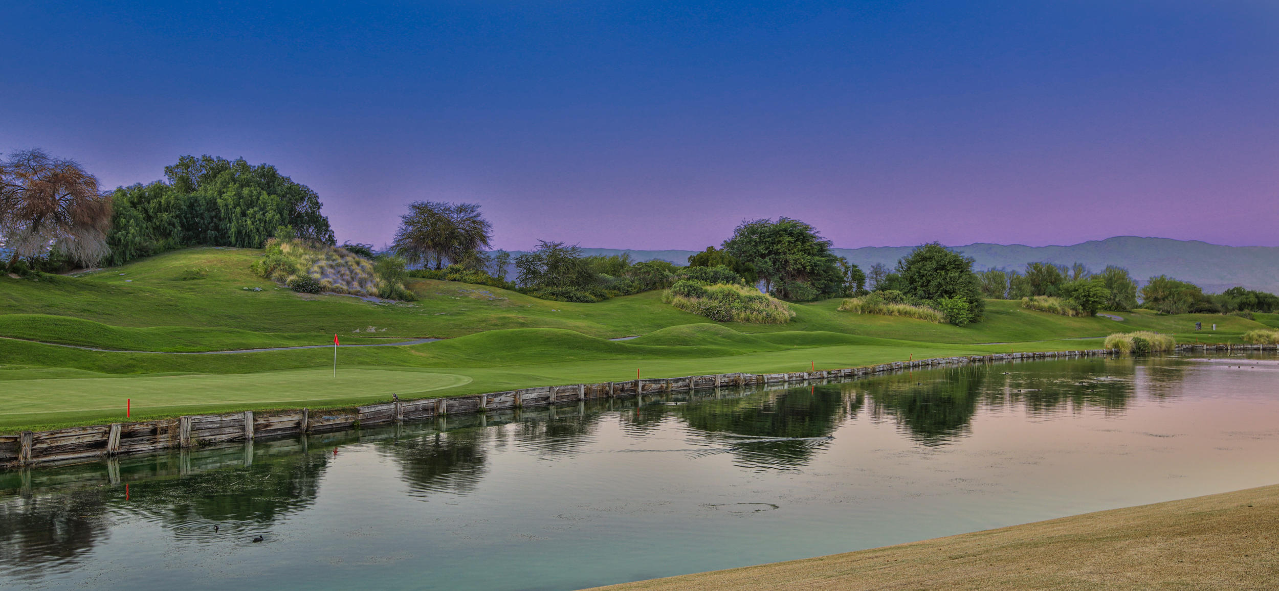360 Loch Lomond Road Rancho Mirage, CA 92270 - Photo 48 of 76 a view of a lake with a house in the background