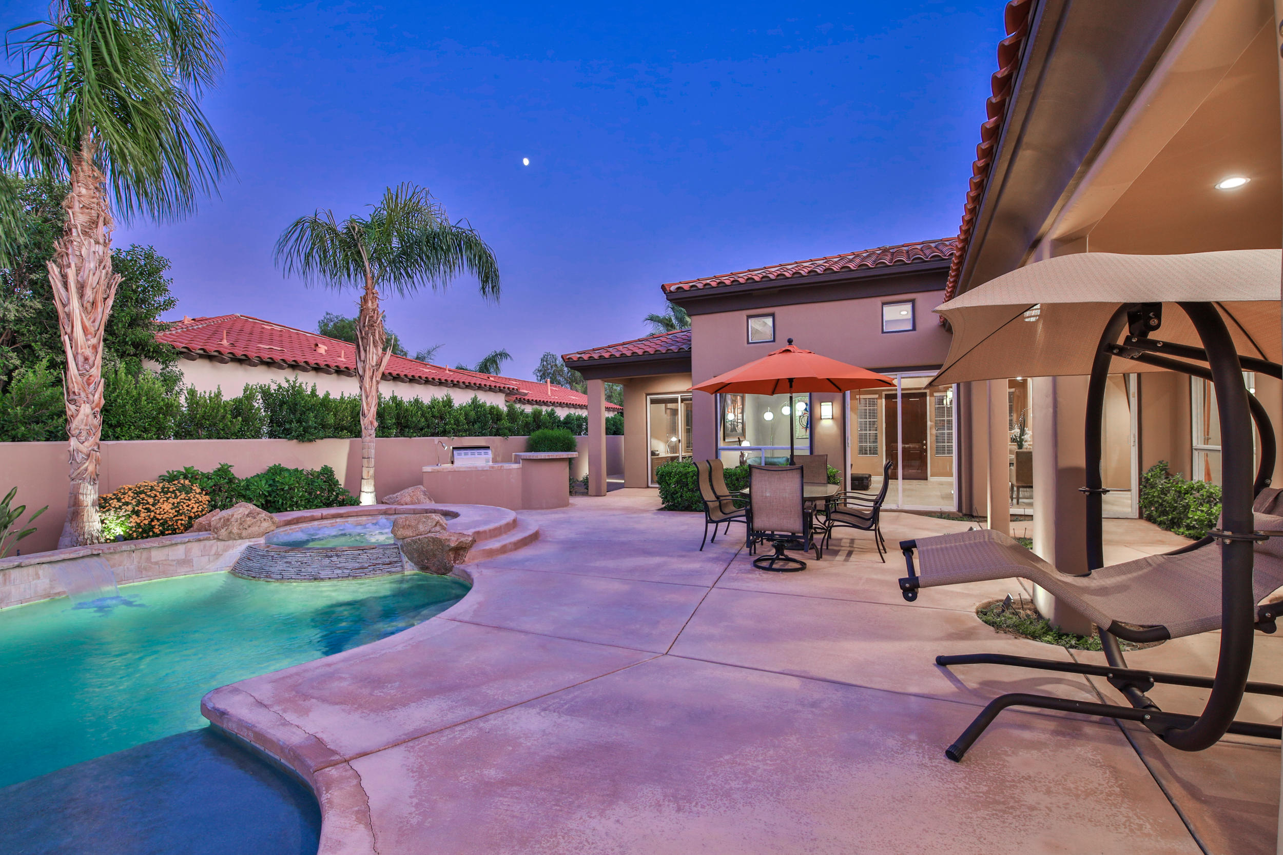 360 Loch Lomond Road Rancho Mirage, CA 92270 - Photo 53 of 76 a view of a patio with a table and chairs under an umbrella