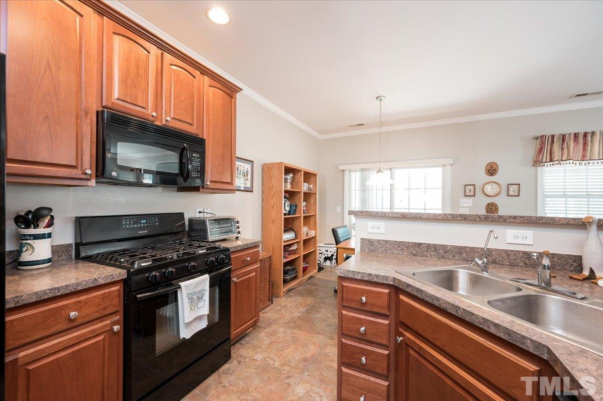 3900 Joe And Ruth Lee Drive Raleigh, NC 27610 - Photo 6 of 25 a kitchen with granite countertop a sink a stove and cabinets