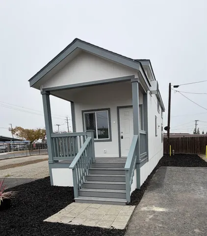 a view of a house with a small yard and wooden floor and fence