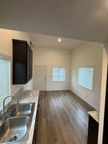 a kitchen with wooden floor and a sink
