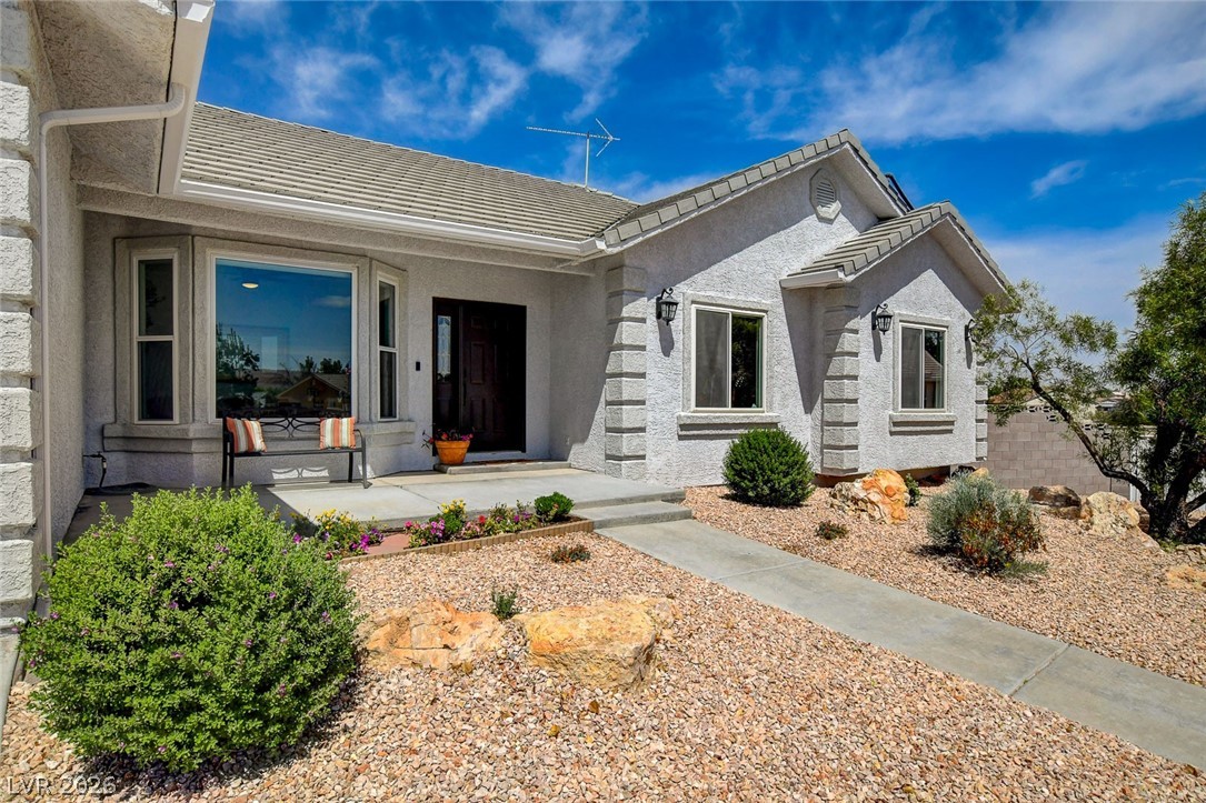 4362 Thistle Street Logandale, NV 89021 - Photo 6 of 99 A welcoming stucco facade with a covered entry and desert-friendly landscaping.