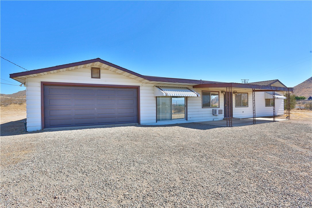 19616 Huasna Road Apple Valley, CA 92307 - Photo 3 of 48 a front view of a house with a yard and garage