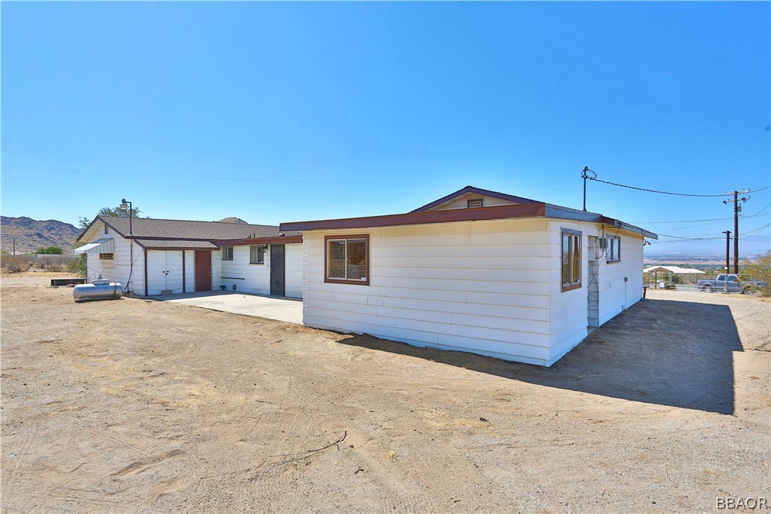 19616 Huasna Road Apple Valley, CA 92307 - Photo 34 of 48 a front view of a house with a yard and garage