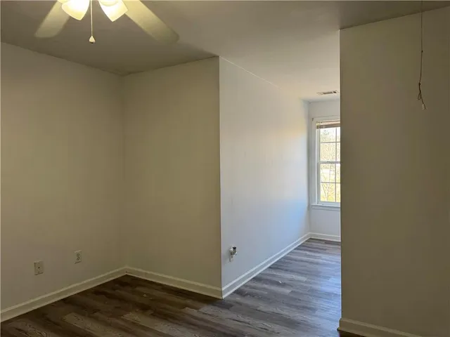 a view of small space with wooden floor and a window