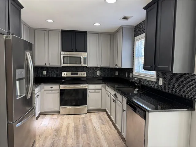 a kitchen with granite countertop stainless steel appliances and wooden cabinets