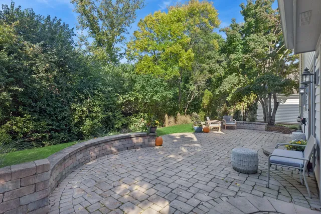 a view of a backyard with table and chairs plants and trees