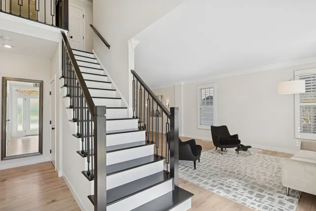 a view of a livingroom with wooden floor and stairs