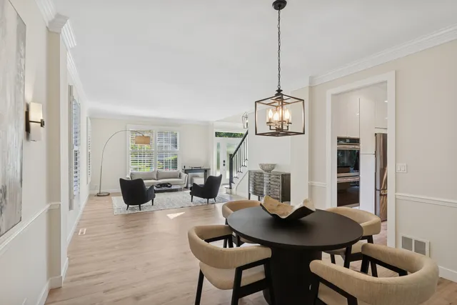 a living room with furniture a chandelier and a wooden floor