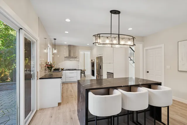a kitchen with stainless steel appliances kitchen island granite countertop a sink and refrigerator