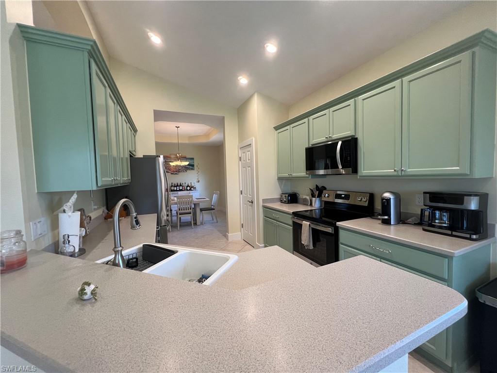 6809 Ascot Drive, Unit 201 Naples, FL 34113 - Photo 13 of 37 a kitchen with stainless steel appliances a sink a stove top oven a counter space and cabinets