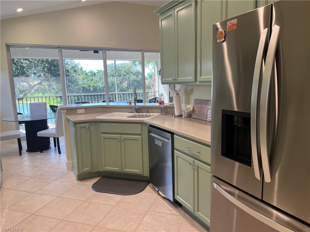 6809 Ascot Drive, Unit 201 Naples, FL 34113 - Photo 15 of 37 a kitchen with a refrigerator and a sink