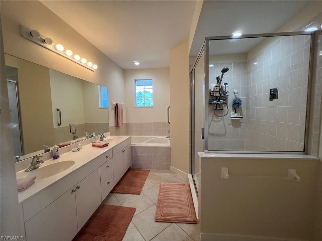 6809 Ascot Drive, Unit 201 Naples, FL 34113 - Photo 19 of 37 a spacious bathroom with a double vanity sink a mirror and a shower