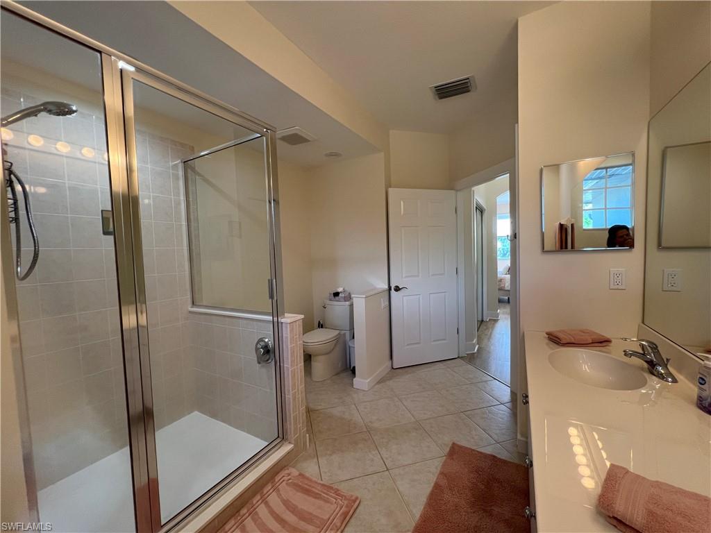 6809 Ascot Drive, Unit 201 Naples, FL 34113 - Photo 20 of 37 a bathroom with a glass shower door and a sink