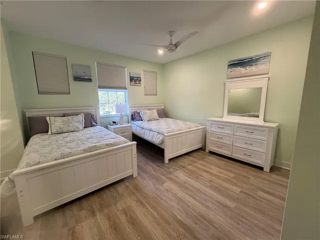 a bedroom with two beds and painting on the wall