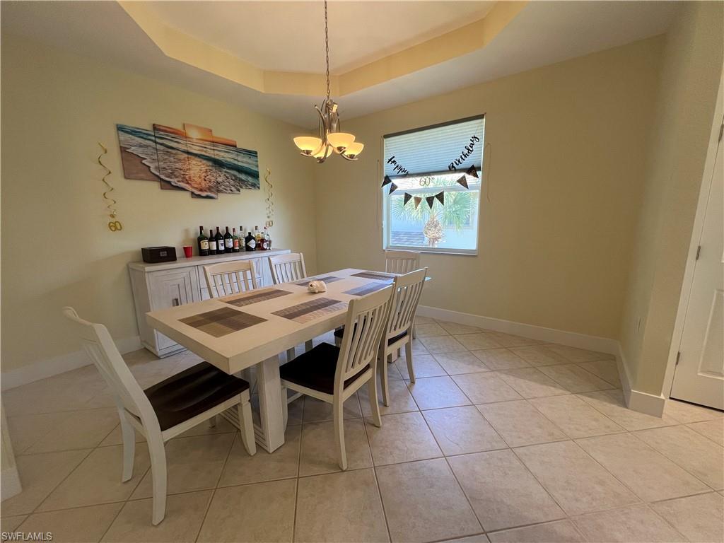 6809 Ascot Drive, Unit 201 Naples, FL 34113 - Photo 6 of 37 a view of a dining room with furniture and chandelier