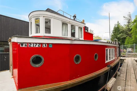 a view of a red door of the house with a car park