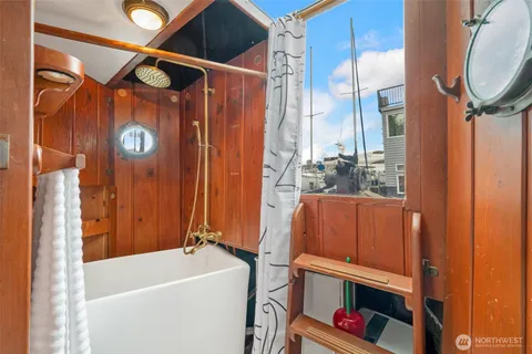 a bathroom with a bathtub a shower and a window