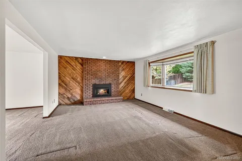 an empty room with windows and fireplace