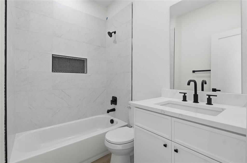 3905 Blue Ridge Boulevard Dallas, TX 75233 - Photo 22 of 25 White vanity with an integrated rectangular sink, matte black two-handle faucet, and white cabinet storage