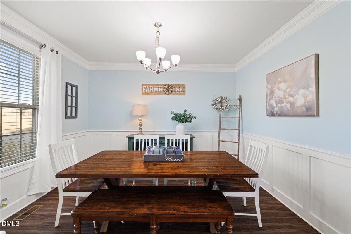 7804 Charters End Street Willow Spring, NC 27592 - Photo 14 of 43 a view of a dining room with furniture wooden floor and chandelier