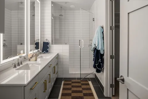 a bathroom with a double vanity sink a mirror and a shower