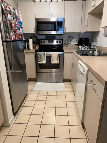 a kitchen with stainless steel appliances a stove a microwave and a sink