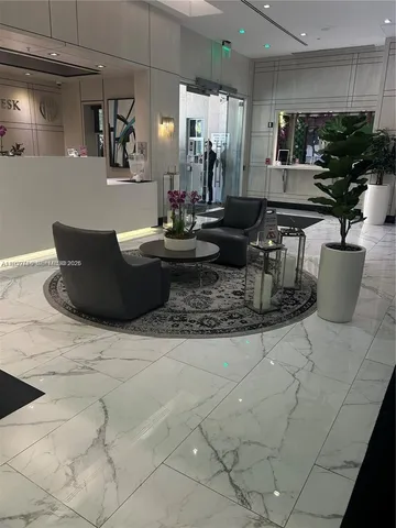 a living room with couches and kitchen view with wooden floor