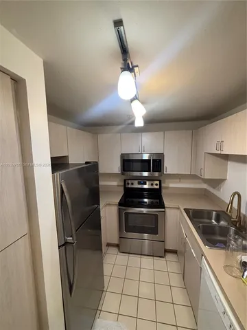 a kitchen with stainless steel appliances a stove a sink and a refrigerator