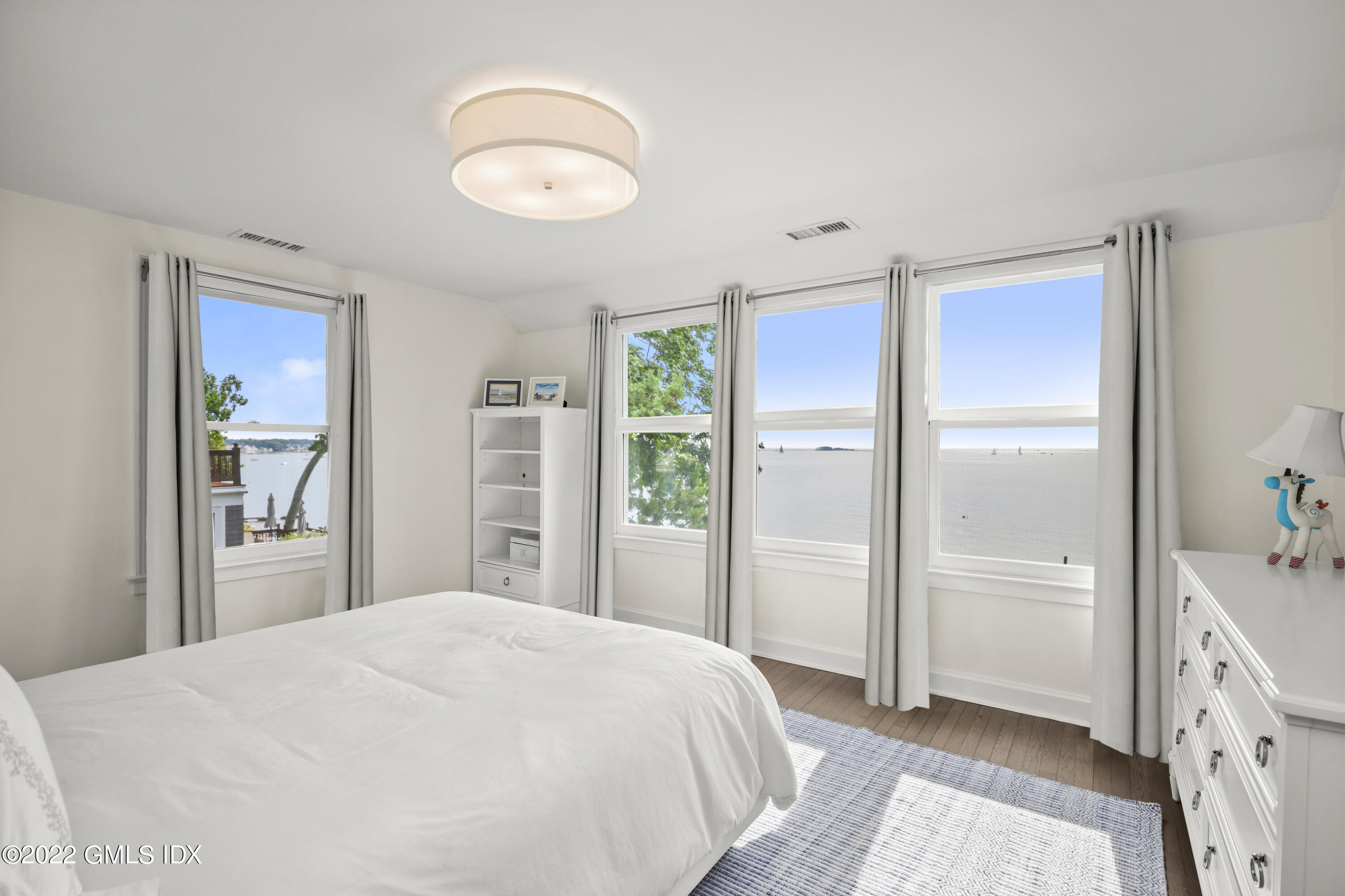 53 Shore Road Clinton, CT 06413 - Photo 17 of 32 a bedroom with a bed and a chandelier