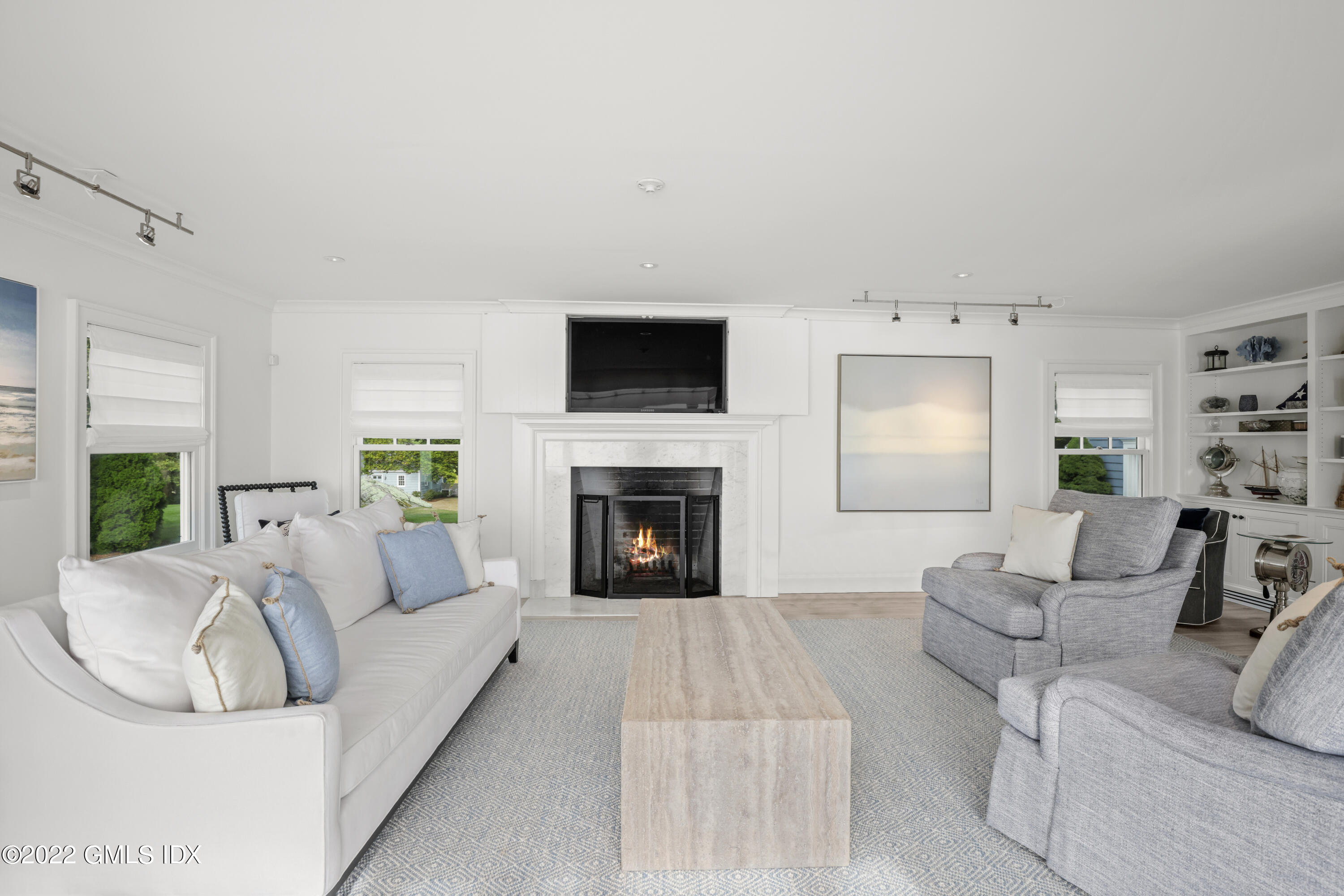 53 Shore Road Clinton, CT 06413 - Photo 19 of 32 a living room with furniture a fireplace and a flat screen tv