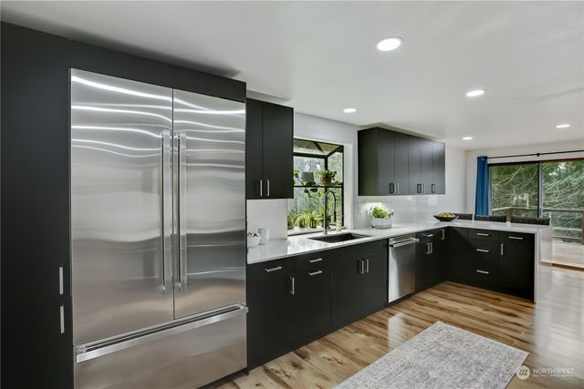 a kitchen with a sink refrigerator and cabinets