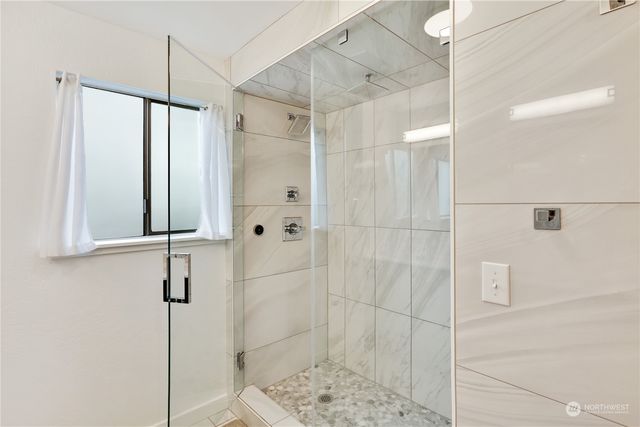 a bathroom with a shower and a glass door