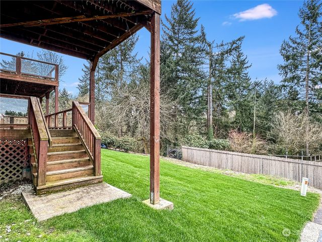 a view of a backyard with wooden fence and a stairs