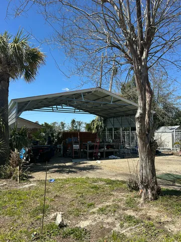 a view of a patio with a table and chairs under an umbrella