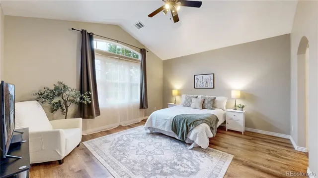 a bedroom with a large bed and wooden floor