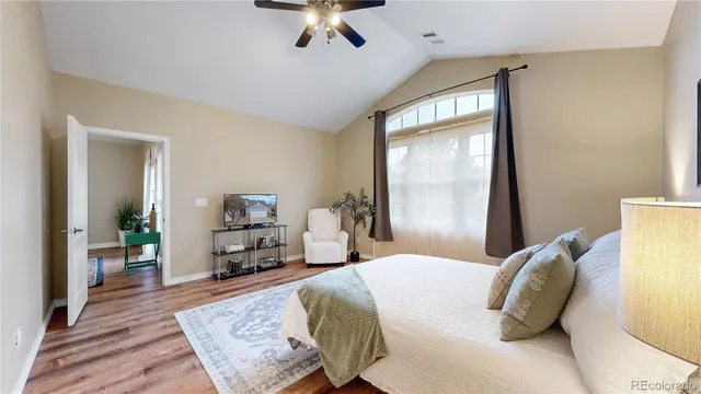 a bedroom with a bed and a dresser with wooden floor