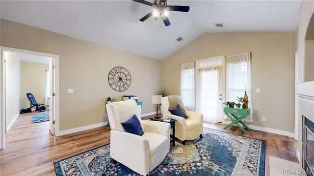 a living room with furniture a large window and a potted plant