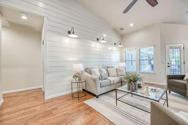 a living room with furniture wooden floor and a chandelier