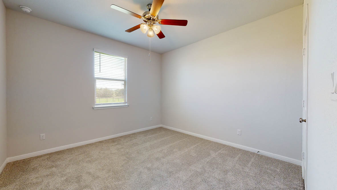 808 Gauge Road Thorndale, TX 76577 - Photo 21 of 31 A quiet retreat with a window overlooking green pastures and a ceiling fan for comfort.