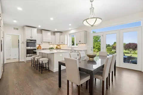 a view of a dining room with furniture a chandelier and wooden floor