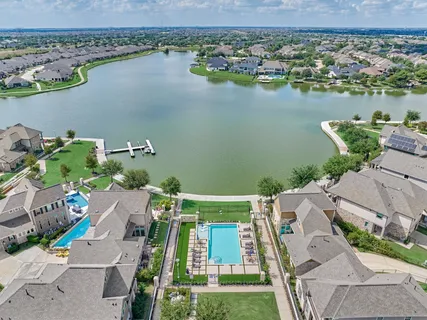 an aerial view of residential houses with outdoor space and lake view