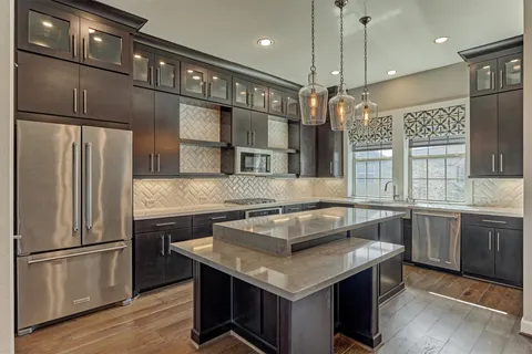 a kitchen with a refrigerator a sink and wooden floor