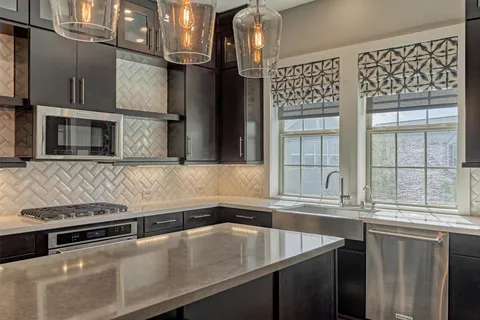 a kitchen with stainless steel appliances a sink and a stove next to a window