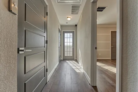 a view of a hallway with wooden floor and staircase